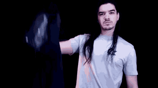 a man with long hair and a beard is wearing a white t-shirt .