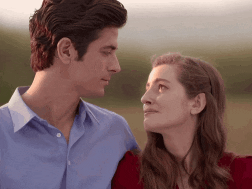 a man and a woman are looking at each other with their eyes closed