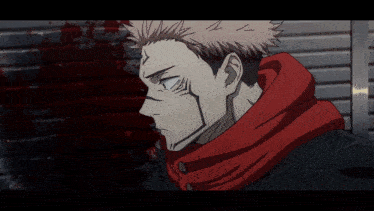 a man with a red scarf around his neck is standing in front of a wall with blood on it