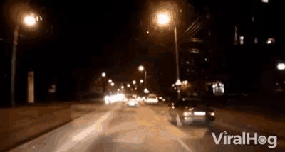 a video of a car driving down a street at night with the words viralhog on the bottom