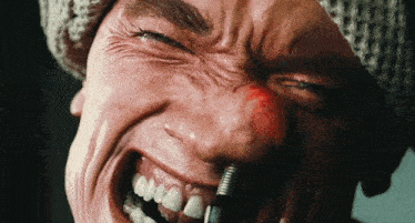 a close up of a man 's face with a red nose
