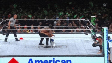 two wrestlers in a wrestling ring with an american sign behind them