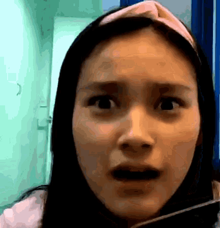 a close up of a woman 's face with her mouth open