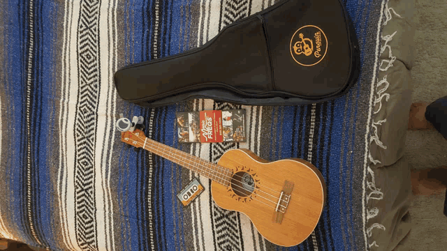 a guitar is laying on a bed next to a bag that says gto