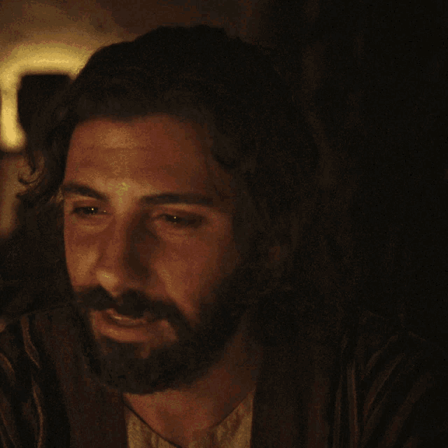 a man with a beard is smiling in a dark room