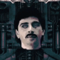 a man with a mustache is standing in a dark room