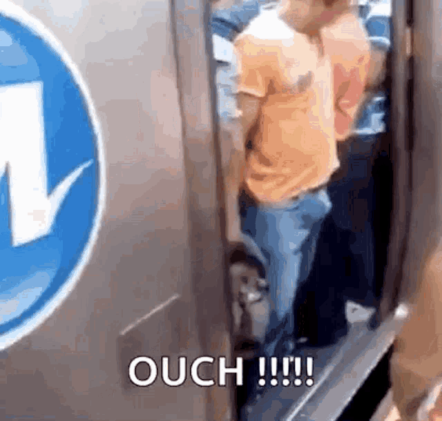 a group of people are standing in an elevator with the words ouch written on the side of the door .