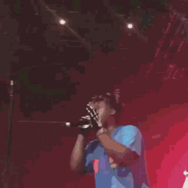 a blurry image of a person standing in front of a microphone