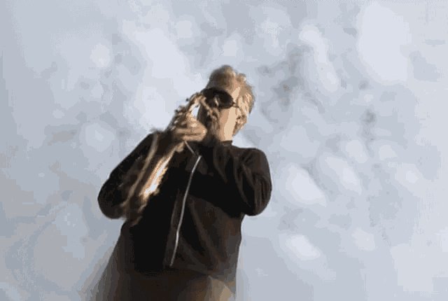 a man is playing a saxophone in the clouds
