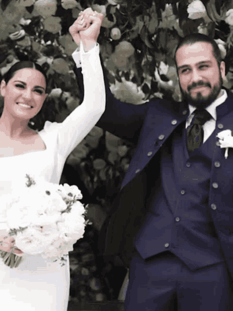 the bride and groom are holding hands and smiling for the camera