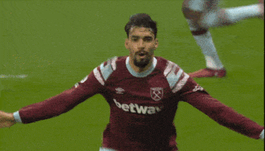 a soccer player wearing a betway jersey holds his head in his hands