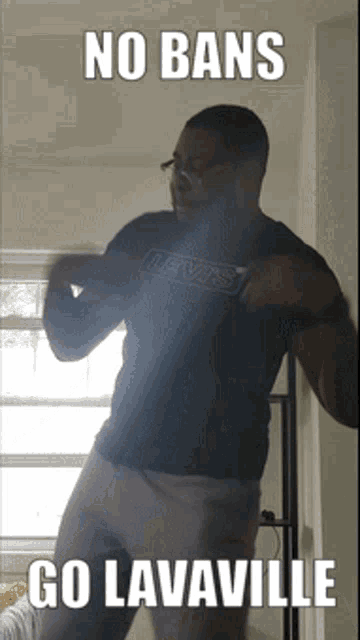 a man in a levis shirt is standing in front of a window