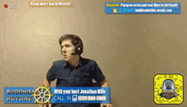a man wearing a headset is standing in front of a buddhist hotline sign