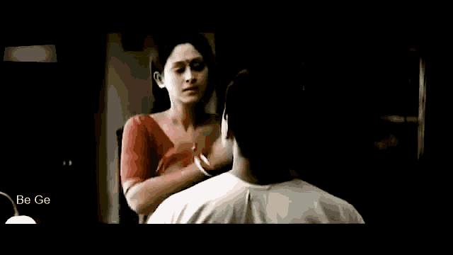 a woman in a red top is looking at a man in a white shirt .