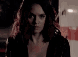 a close up of a woman 's face with a serious look on her face at night .