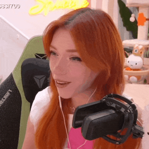 a woman with red hair is wearing headphones in front of a microphone that says minecraft on the back