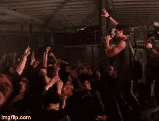 a man singing into a microphone in front of a crowd with imgflip.com in the lower right corner