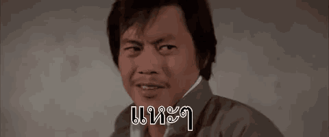 a man is smiling and talking on a cell phone in a foreign language .