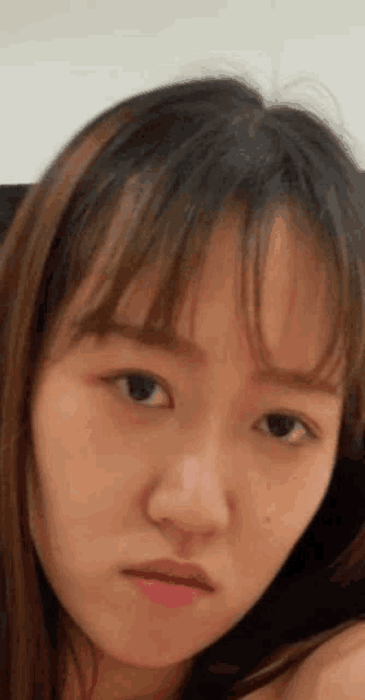 a close up of a woman 's face with a serious expression .