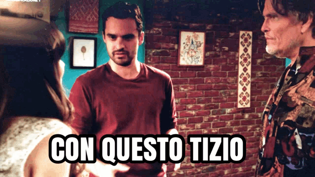 a man in a red shirt is standing in front of a brick wall with the words con questo tizio above him