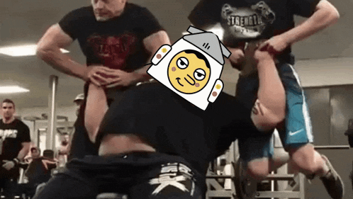a man is doing a crunch in a gym with a robot head on his head .