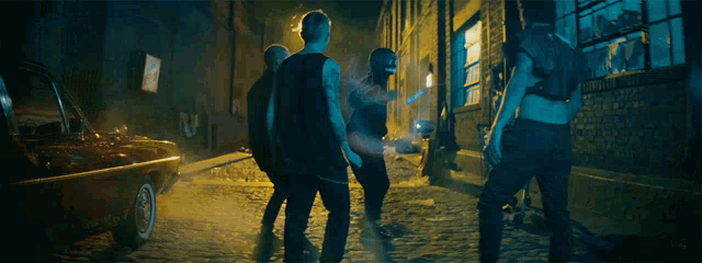 a group of people are walking down a cobblestone street