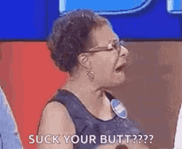 a woman is sitting on a stage with her mouth open and saying `` suck your butt ? '' .