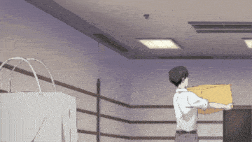 a man in a white shirt is holding a yellow box in a room