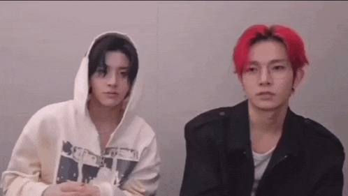 two men with red hair are sitting next to each other and looking at the camera .