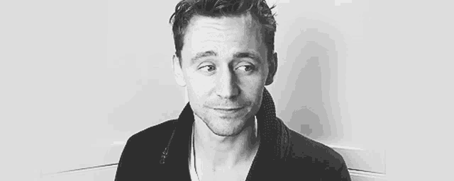 a black and white photo of a man making a face .