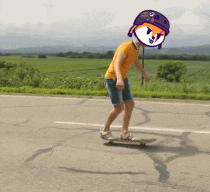 a person is riding a skateboard down a road with a cartoon face on their head