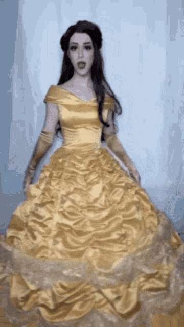 a woman in a yellow dress and gloves is standing in front of a blue curtain