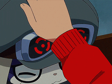 a person wearing a red sweater is touching a robot 's head