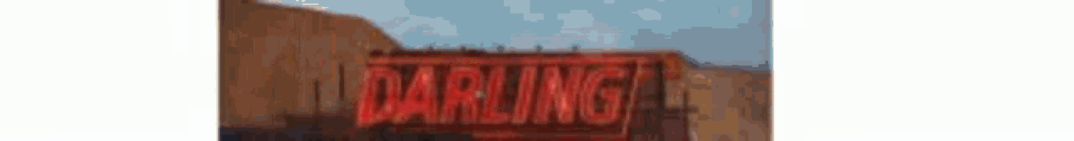 a blurry picture of a red sign that says darling on it .