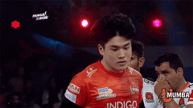 a man in a mumba jersey stands in front of a red light