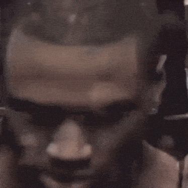 a close up of a man 's face with his mouth open and ear piercings .