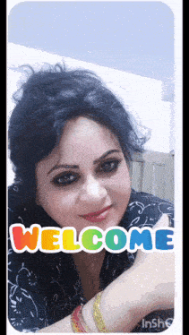 a woman is giving a thumbs up with a welcome sticker on her face