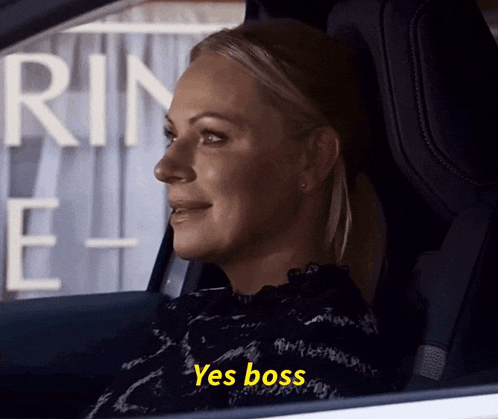 a woman in a car says yes boss in yellow letters