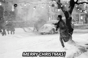 a black and white photo of a person hanging upside down in the snow with the words `` merry christmas '' .