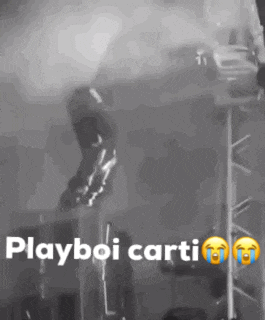 a black and white photo of a person jumping off a stage with the words playboi carti written on it .
