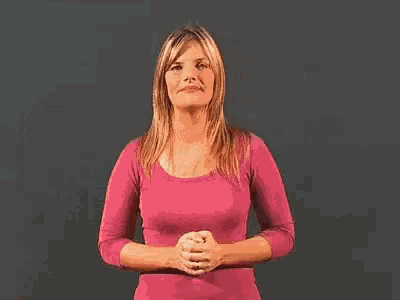 a woman in a pink shirt is making a funny face .