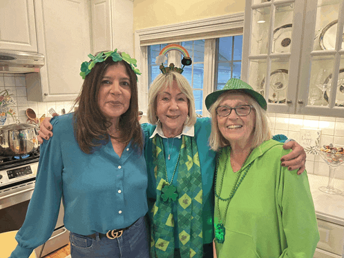 three women are posing for a picture in a kitchen and one has a gucci belt