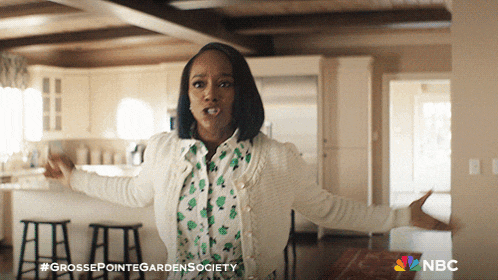 a woman is standing in a kitchen with her arms outstretched and the words grosse pointe garden society on the bottom right