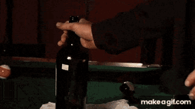 a man is drinking a glass of whiskey with a straw .