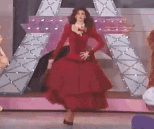 a woman in a red dress is dancing on stage .