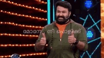 a man with a beard is giving a thumbs up in front of a wall of lights .