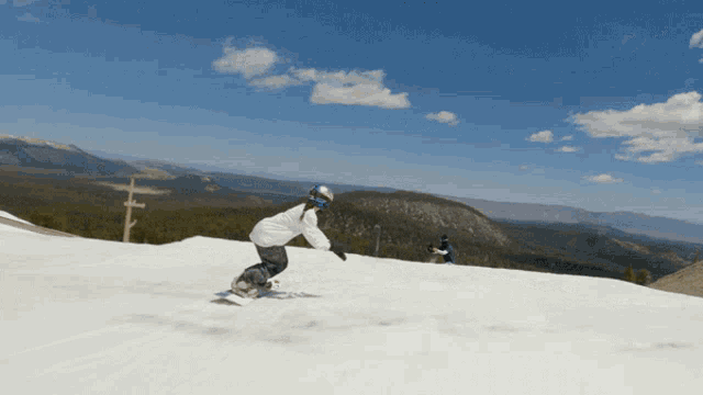 a person riding a snowboard down a snowy hill