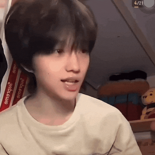 a young boy with short hair is making a funny face in a room .