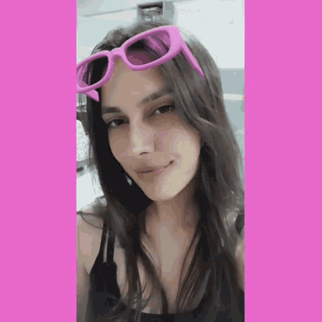 a woman wearing a pair of pink sunglasses