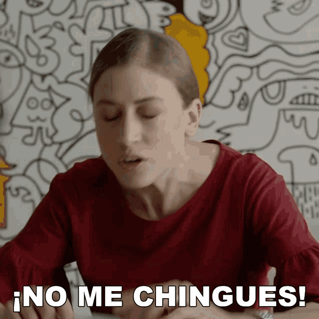 a woman says no me chingues in front of a drawing wall